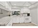 Well-lit kitchen featuring ample counter space, a white tile backsplash, and white appliances at 3615 Greatwood Ct, Land O Lakes, FL 34639