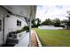 Backyard view with a stone walkway leading to a white home with a pool at 38819 Otis Allen Rd, Zephyrhills, FL 33540