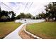 Large backyard with a stone walkway to a partially enclosed pool area at 38819 Otis Allen Rd, Zephyrhills, FL 33540