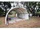Covered carport area ideal for vehicle storage or outdoor projects, with trees in the background at 38819 Otis Allen Rd, Zephyrhills, FL 33540