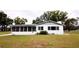 Charming single-story home featuring a bright white exterior, screened-in porch, and a well-maintained grassy yard at 38819 Otis Allen Rd, Zephyrhills, FL 33540