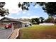 Sprawling front lawn and a single-story home featuring an attached carport and long driveway at 38819 Otis Allen Rd, Zephyrhills, FL 33540