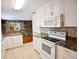 Bright kitchen features white cabinetry, granite countertops, tile backsplash, and stainless steel appliances at 38819 Otis Allen Rd, Zephyrhills, FL 33540