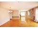 Spacious living room featuring gleaming hardwood floors, stone accent wall, and elegant chandelier at 38819 Otis Allen Rd, Zephyrhills, FL 33540