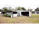 View of the shed with a partially open garage door and some items inside at 38819 Otis Allen Rd, Zephyrhills, FL 33540