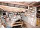 Interior view of the shed featuring wooden beams, a workbench, and shelves stocked with various items at 38819 Otis Allen Rd, Zephyrhills, FL 33540
