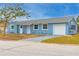Charming blue single-Gathering home with a well-maintained front yard and an attached single car garage at 410 Virginia Ave, Madeira Beach, FL 33708