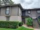 Exterior view of condo showing stairs to units with neutral color scheme, contrasted by dark trim and a tidy landscape at 4111 Ashford Green Pl # B203, Tampa, FL 33613
