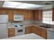 Efficient kitchen featuring white appliances, wood cabinets, laminate countertops, and lots of light at 4111 Ashford Green Pl # B203, Tampa, FL 33613