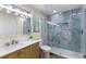 Well-lit bathroom with a wooden vanity, sleek fixtures, and a luxurious walk-in shower with blue accents at 4492 Kingston Dr, Hernando Beach, FL 34607