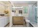 Bright bathroom with a modern vanity, beautiful mirror and a walk-in shower with blue tiling at 4492 Kingston Dr, Hernando Beach, FL 34607
