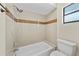 Tiled bathtub and shower combination with updated fixtures and neutral color palette at 4509 Grainary Ave, Tampa, FL 33624