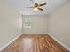 Cozy bedroom featuring a ceiling fan, hardwood floors, and a bright window at 4509 Grainary Ave, Tampa, FL 33624