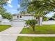 Charming two-story home with well-maintained landscaping, a paved driveway, and attached garage at 4509 Grainary Ave, Tampa, FL 33624