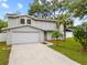 Charming two-story home with a well-manicured lawn and attached garage at 4509 Grainary Ave, Tampa, FL 33624