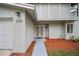 Inviting front entrance with double doors, manicured landscaping, and attached garage at 4509 Grainary Ave, Tampa, FL 33624