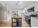 Well-lit kitchen showcasing white cabinets, stainless steel appliances, a kitchen island, and wood-style floors at 4509 Grainary Ave, Tampa, FL 33624