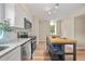 Bright kitchen featuring a central island, stainless appliances, white cabinetry, and wood-look flooring at 4509 Grainary Ave, Tampa, FL 33624