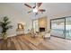 Bright living room with a stone fireplace, wood floors, and views of the screened pool at 4509 Grainary Ave, Tampa, FL 33624