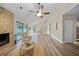 Spacious living room with a stone fireplace, ceiling fan, and lots of natural light at 4509 Grainary Ave, Tampa, FL 33624