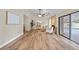 Bright living room featuring wood floors, a ceiling fan, fireplace, and sliding glass doors to a pool area at 4509 Grainary Ave, Tampa, FL 33624