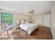 Bright main bedroom showcasing hardwood floors, a ceiling fan, and ample space at 4509 Grainary Ave, Tampa, FL 33624