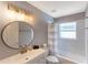 Bright bathroom featuring a round mirror over the vanity, with neutral tones and natural light at 4531 River Overlook Dr, Valrico, FL 33596