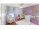 Charming Bedroom with dual cribs, decorative wall accents, and a cozy armchair perfect for a young Gathering at 4531 River Overlook Dr, Valrico, FL 33596