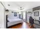 Bedroom featuring gray walls, hardwood floors, large ceiling fan, and modern desk with gaming chair at 4531 River Overlook Dr, Valrico, FL 33596