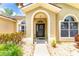 Close-up of front entrance with decorative wreath and arched entry; beautiful landscaping at 4531 River Overlook Dr, Valrico, FL 33596