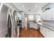 Well-lit kitchen showcases stainless steel appliances, white cabinets, hardwood floors, and granite countertops at 4531 River Overlook Dr, Valrico, FL 33596