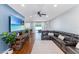 Spacious living room with dark leather sectional, ceiling fan, and large sliding doors at 4531 River Overlook Dr, Valrico, FL 33596