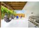 Secluded backyard patio features egg swing chairs, fire pit, barbecue, and tropical landscaping at 4916 Palmetto Point Dr, Palmetto, FL 34221