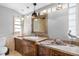 Bathroom features a wooden vanity with dual sinks, decorative mirrors, and elegant lighting fixtures at 4916 Palmetto Point Dr, Palmetto, FL 34221