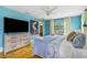 Bright bedroom features an open doorway, ceiling fan, wood floors, and a large TV at 4916 Palmetto Point Dr, Palmetto, FL 34221