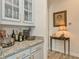 The bar area features granite countertops, glass-front cabinets, and ample storage space at 4973 Antiquity Way, Sarasota, FL 34240