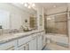 Bathroom featuring dual sinks with granite countertops, white cabinets, and a tub-shower combo at 4973 Antiquity Way, Sarasota, FL 34240
