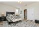 Bedroom showcasing neutral walls, hardwood floors, ensuite bathroom, and a patterned area rug at 4973 Antiquity Way, Sarasota, FL 34240
