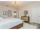 Bedroom showcasing wood floors, neutral walls, a decorative gold accented dresser, and framed art at 4973 Antiquity Way, Sarasota, FL 34240