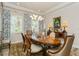 Sophisticated dining room with a large wooden table, modern light fixture, and elegant decor at 4973 Antiquity Way, Sarasota, FL 34240