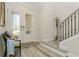 Light-filled foyer featuring decorative glass doors, wood floors, and a staircase with iron railings at 4973 Antiquity Way, Sarasota, FL 34240