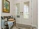 Elegant foyer with decorative glass double doors, a stylish bench, and a tasteful area rug at 4973 Antiquity Way, Sarasota, FL 34240