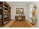 Cozy home office with custom built-in shelving, a traditional desk, and a decorative area rug at 4973 Antiquity Way, Sarasota, FL 34240