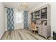 This home office includes a built-in bookcase, a desk, and neutral decor at 4973 Antiquity Way, Sarasota, FL 34240
