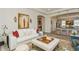 Living room with an elegant white sofa, stylish ottoman, and views into the kitchen area at 4973 Antiquity Way, Sarasota, FL 34240