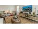 Stylish living room with large screen television, plantation shutters, and comfortable seating at 4973 Antiquity Way, Sarasota, FL 34240