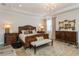 Luxurious main bedroom with a tray ceiling, chandelier, and elegant furniture creating a relaxing space at 4973 Antiquity Way, Sarasota, FL 34240
