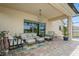 Covered patio with comfortable seating, stylish decor, and an inviting atmosphere for outdoor relaxation at 4973 Antiquity Way, Sarasota, FL 34240