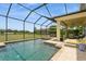 Backyard featuring a screened pool, a spa, a covered lanai, a view of the lake, and lounge chairs at 4973 Antiquity Way, Sarasota, FL 34240