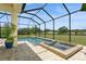 Screened pool and spa area featuring a clear blue pool, brick pavers, and lush landscaping at 4973 Antiquity Way, Sarasota, FL 34240